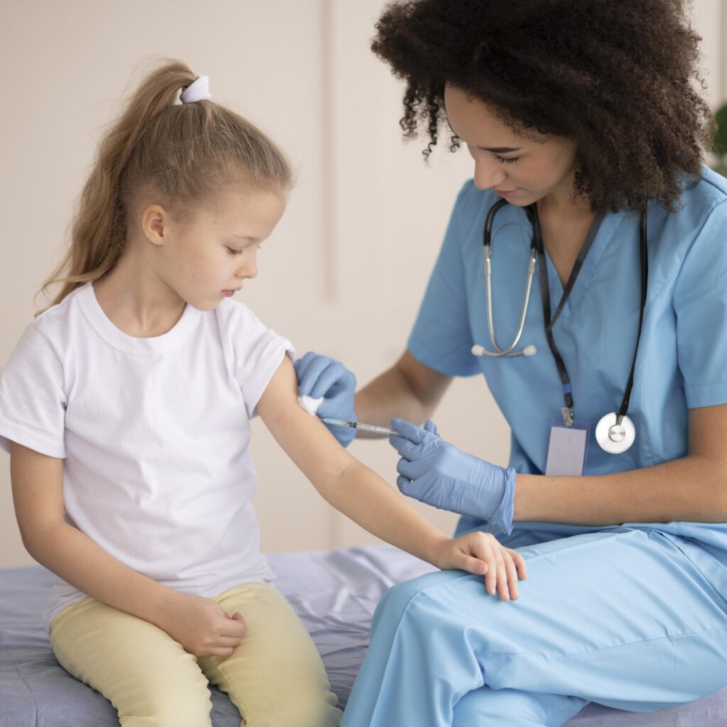 Técnica auxiliar en salud aplicando una vacuna a una niña en consulta de primera infancia