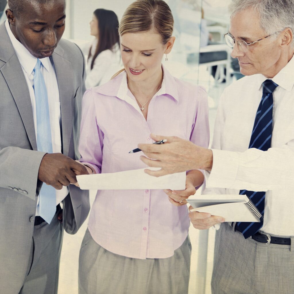 Equipo de profesionales revisando un documento durante una reunión de negociación y ventas