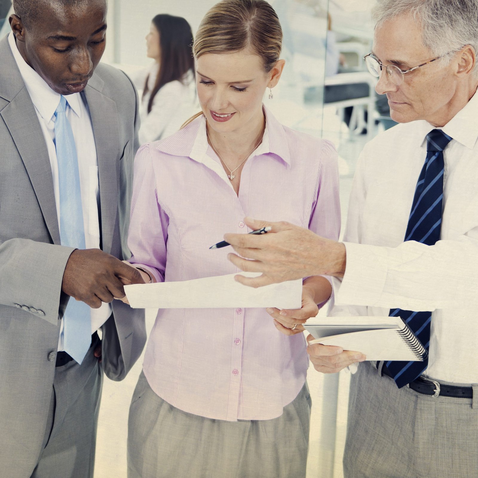 Equipo de profesionales revisando un documento durante una reunión de negociación y ventas