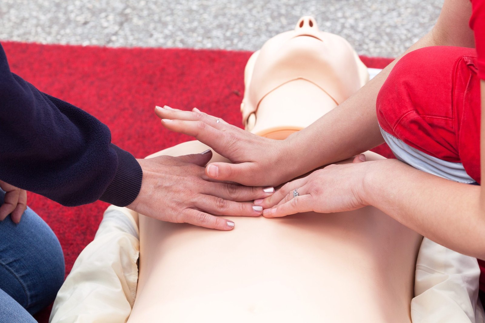 Instructores realizando compresiones torácicas (RCP) en maniquí de entrenamiento